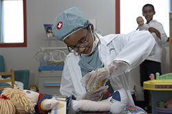 A child plays dress-up as a doctor.
